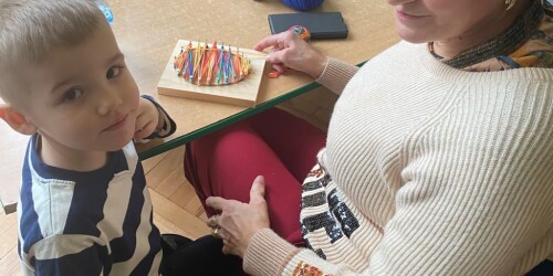 babcia z wnukiem robi pisankę w przedszkolu