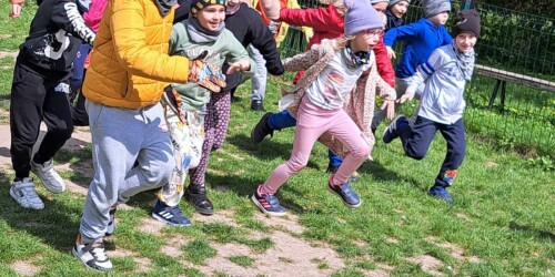 dzieci biegną po boisku
